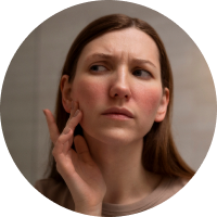 Woman looking at her skin in the mirror